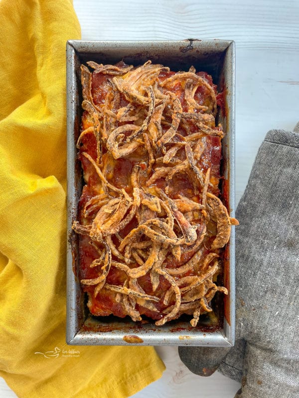 top view of meatloaf in pan with fried onions on top