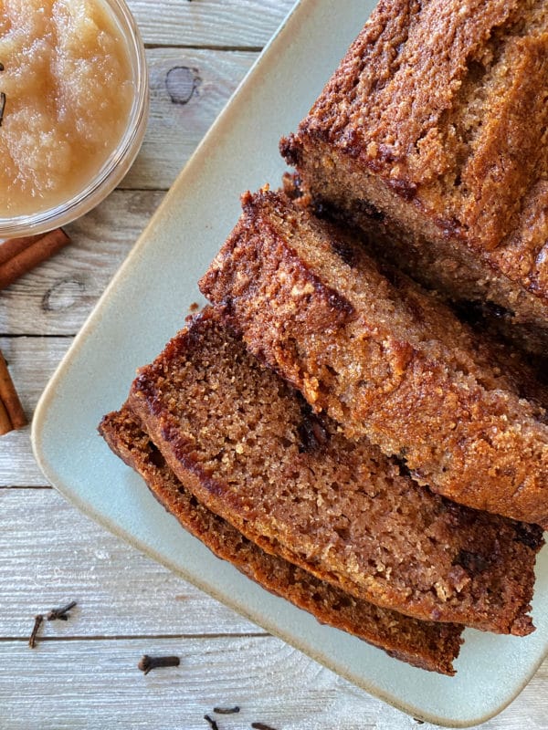 one loaf of applesauce bread on white plate with three slices