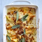 dish with baked potatoes au gratin with melted cheese and crispy bacon