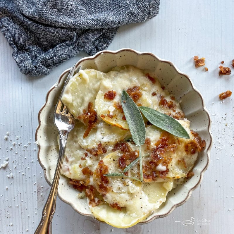 one bowl of potatoes au gratin topped with sage and bacon