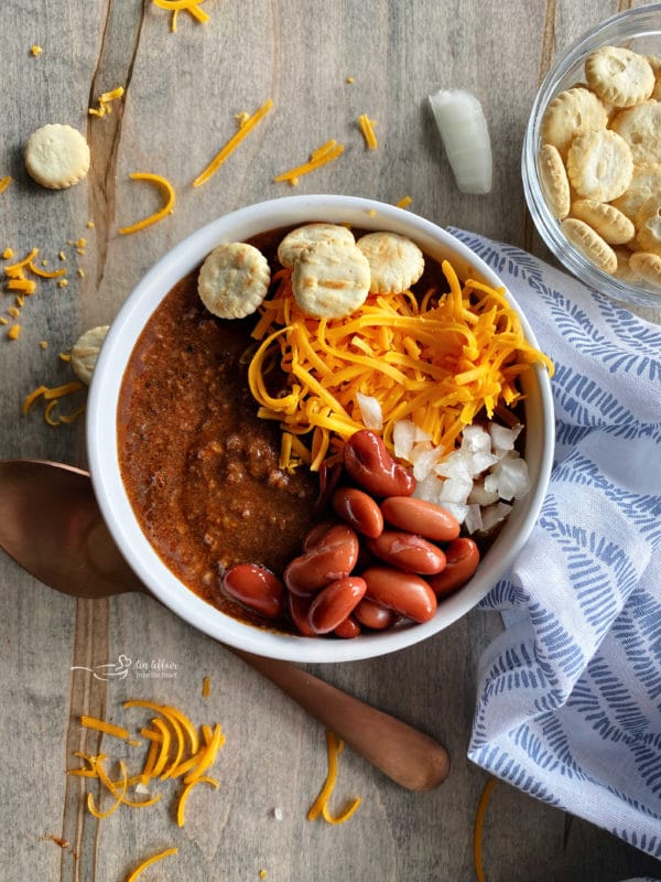 bowl of chili with beans onion and cheese on top