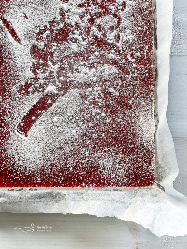 top view of cinnamon rock candy in baking sheet with powdered sugar