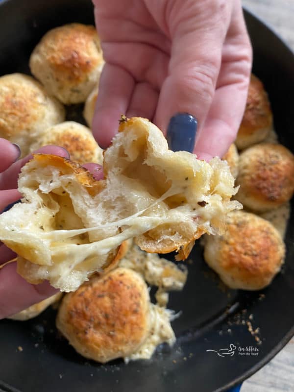 Italian Cheese Bombs hands with cheese pull