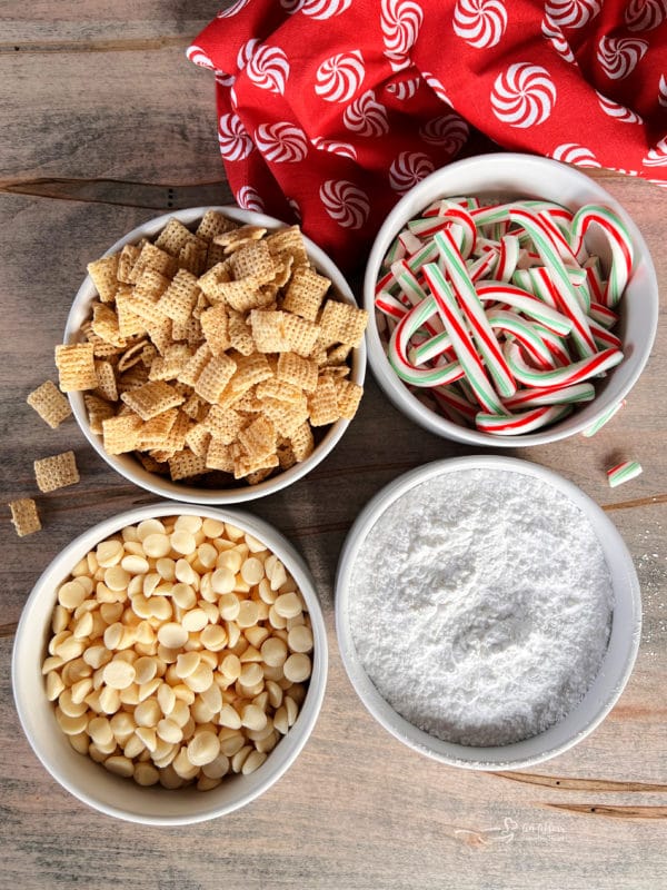 four bowls of chex mix, candy canes, white chocolate, powdered sugar