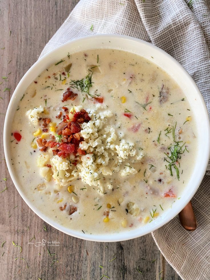 Cheesy Potato Corn Chowder with copper colored spoon and tan napkin