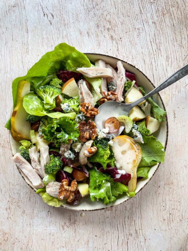 top view of Waldorf salad in bowl with fruit and chicken with spoon