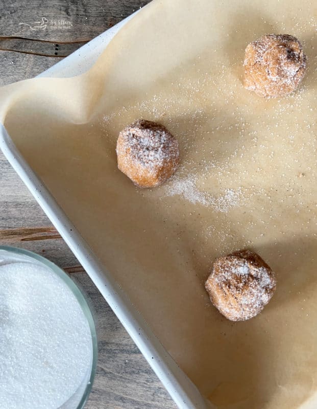 molasses cookie dough balls rolled in sugar on baking sheet 