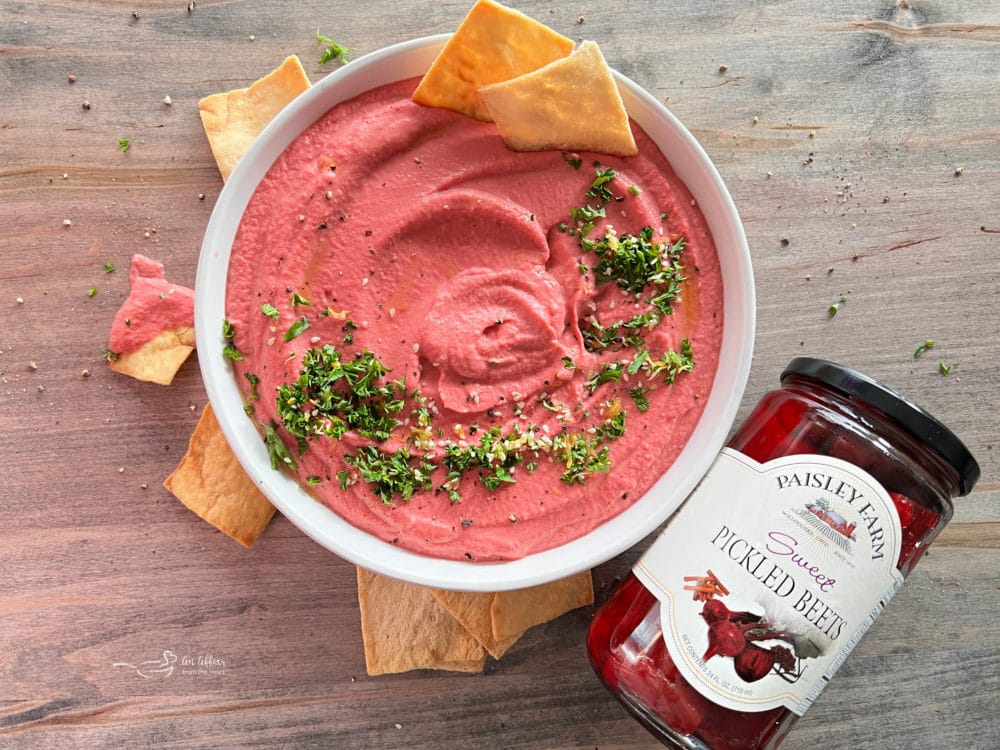 pickled beet hummus with parsley and chips next to jar of pickled beets