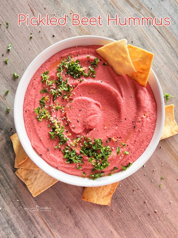 white bowl with pink hummus and crackers