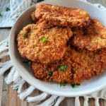 Breaded pork cutlets in a white serving dish