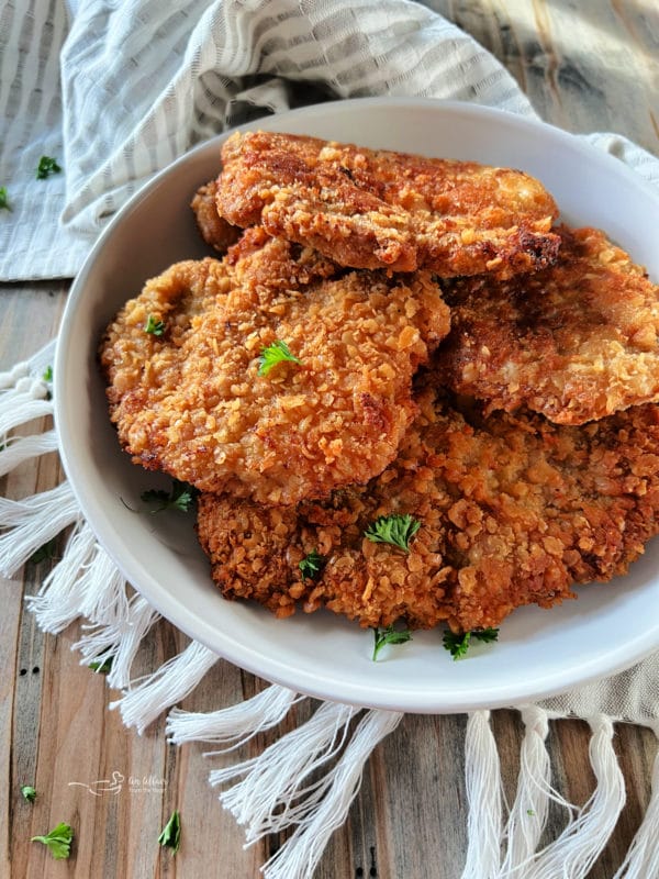 Breaded pork cutlets in a white serving dish