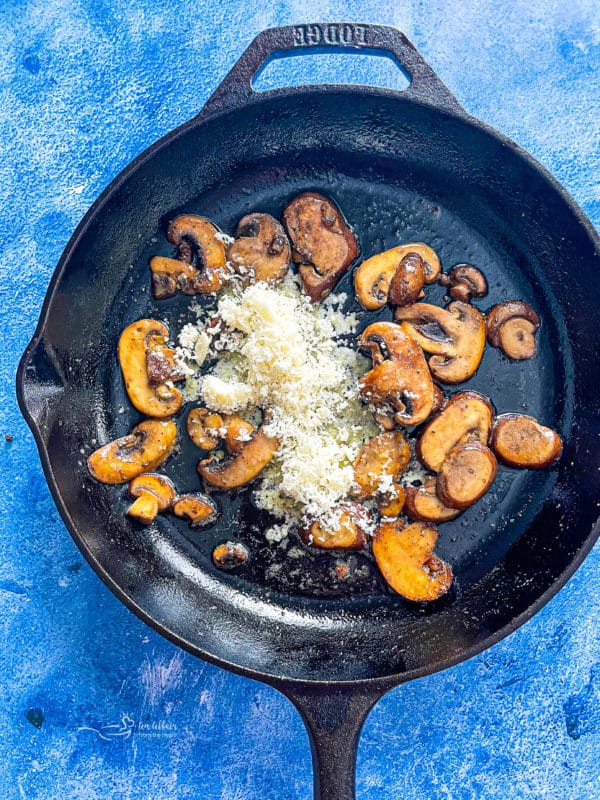 cooking mushrooms in skillet with parmesan, butter, and oil