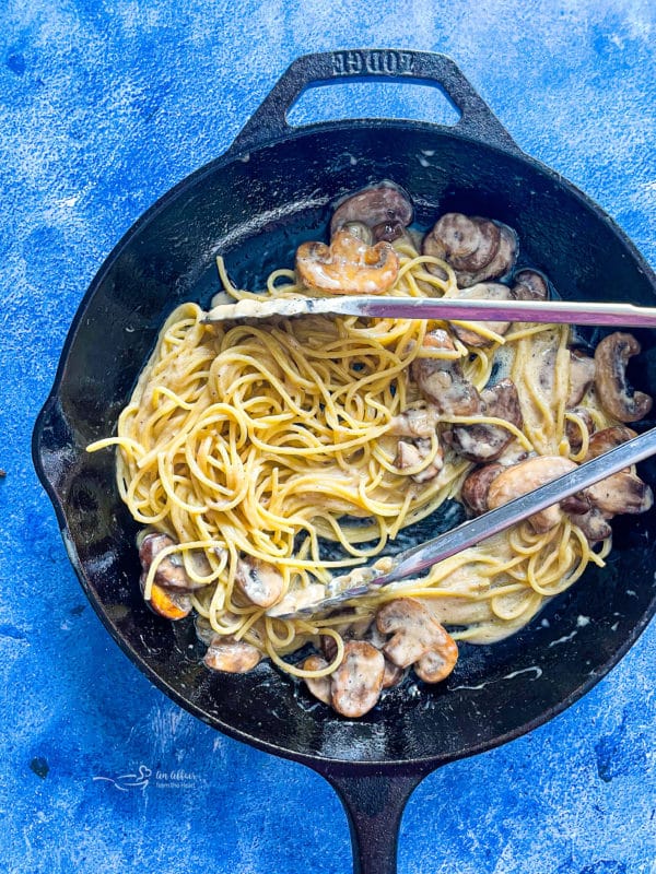 skillet with spaghetti noodles and mushrooms