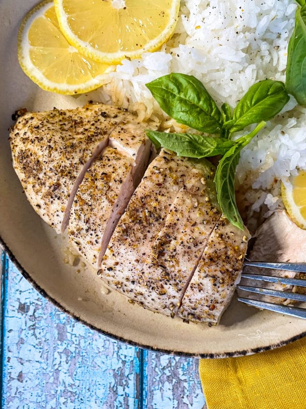 one plate of chicken with lemon and pepper with rice and basil and lemon