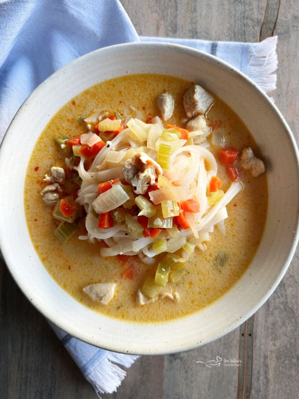 white bowl filled with Asian chicken noodle soup and noodles 