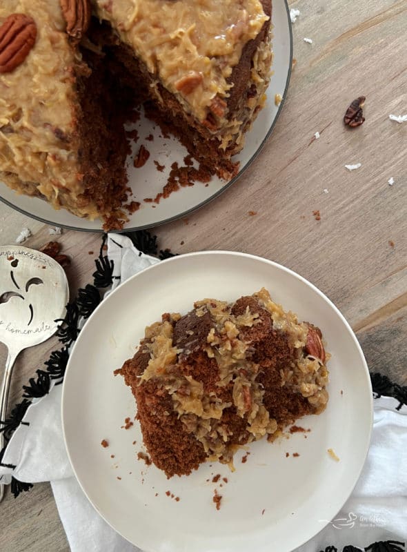 one slice of German chocolate cake on white plate with coconut pecan frosting 