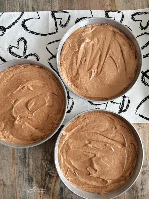 three layers of German chocolate cake batter in pans 