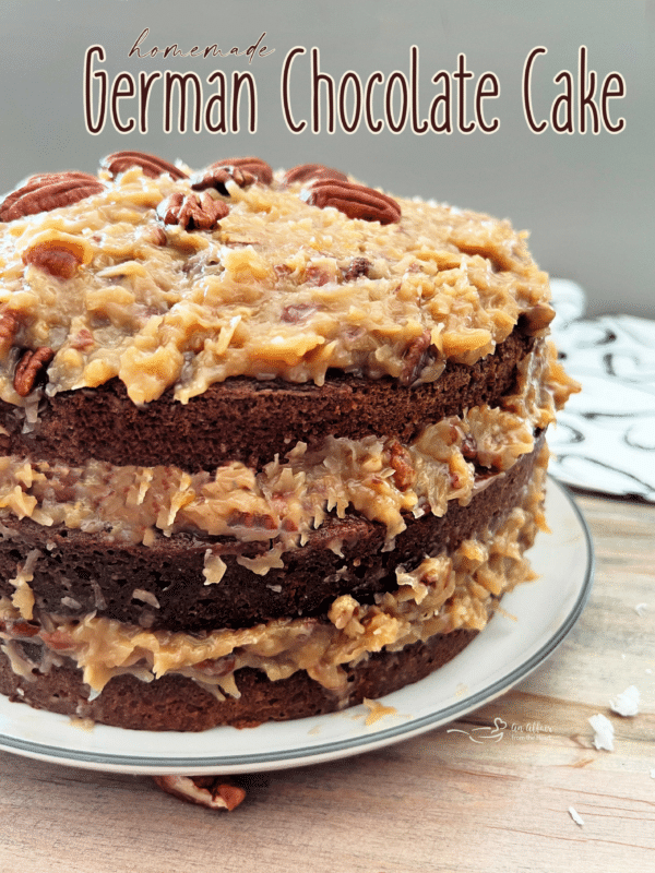 one German chocolate cake on white plate with layers of coconut pecan frosting 