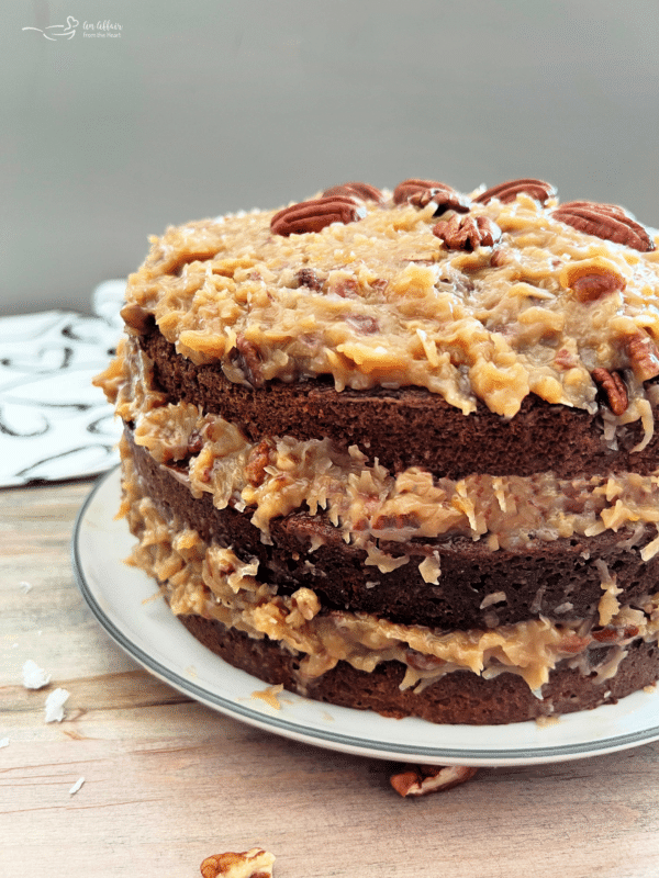 German chocolate cake on white plate with coconut pecan frosting 
