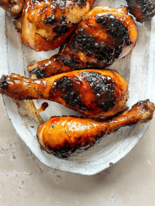 Sweet and sticky grilled chicken legs on a white plate