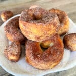 Pumpkin Spice Air Fryer Biscuit Donuts stacked on a white serving plate.