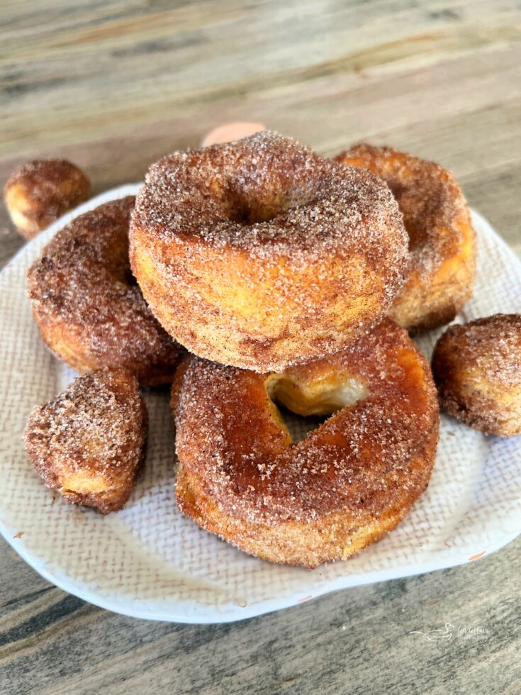 Pumpkin Spice Air Fryer Biscuit Donuts stacked on a white serving plate.