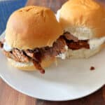 Two spicy beef sliders on a white plate.