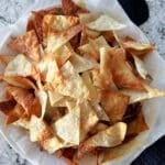 Air fryer wonton chips in a napkin lined bowl.