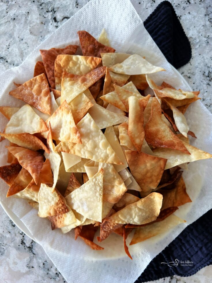 Air fryer wonton chips in a napkin lined bowl.