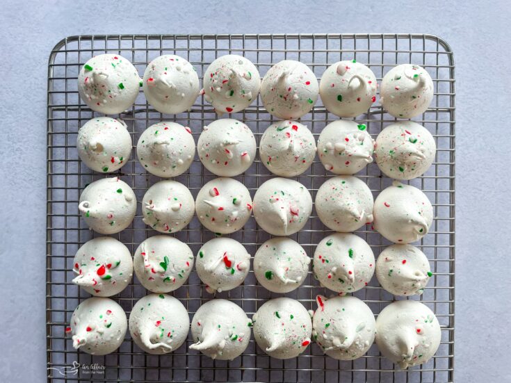 Close up of peppermint Meringues lined up on a cooling rack.
