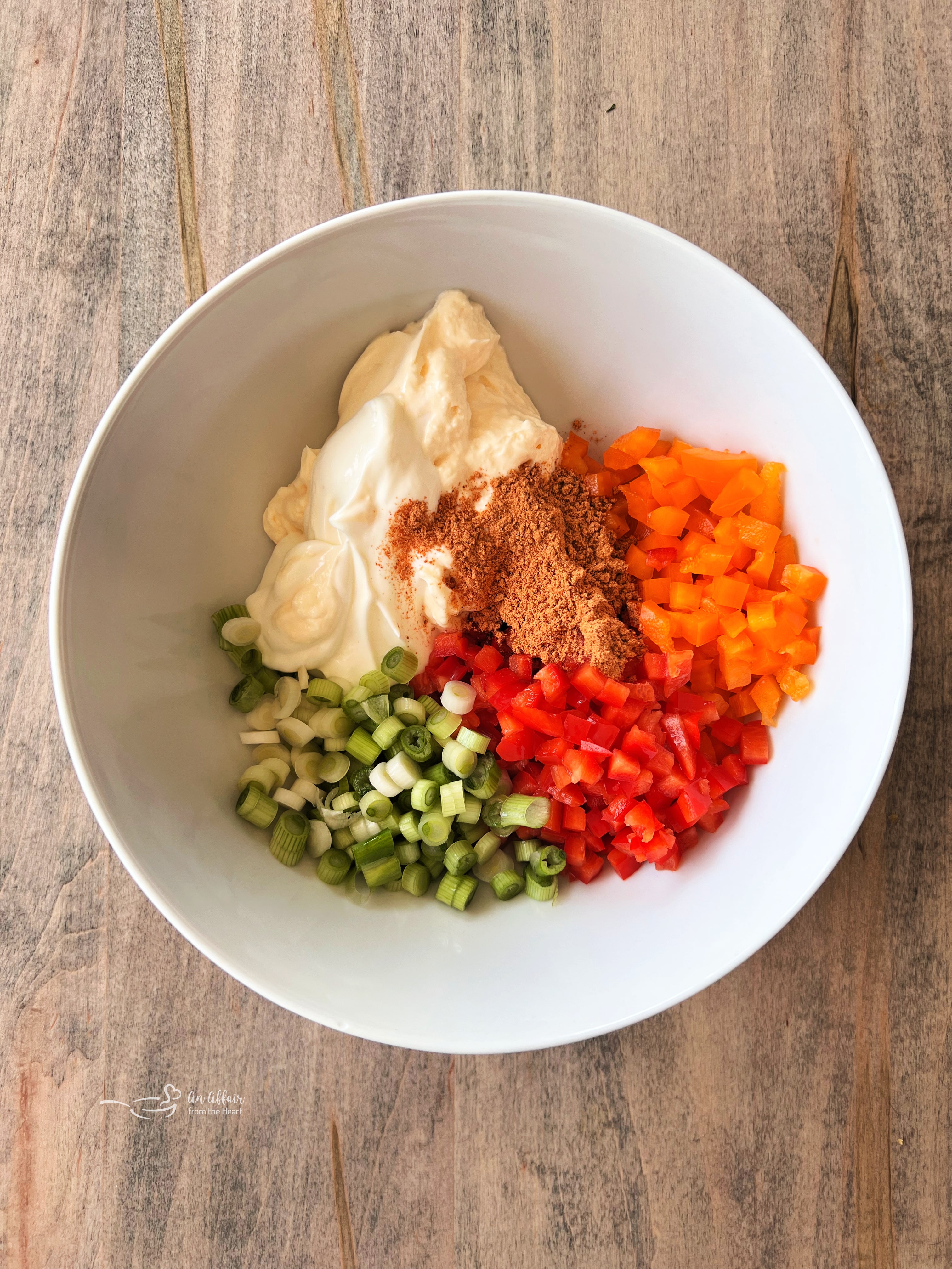 Fiesta Frito Corn Salad 5 Step 1: Combining mayonnaise, sour cream, taco seasoning, bell peppers, and green onions in a large bowl