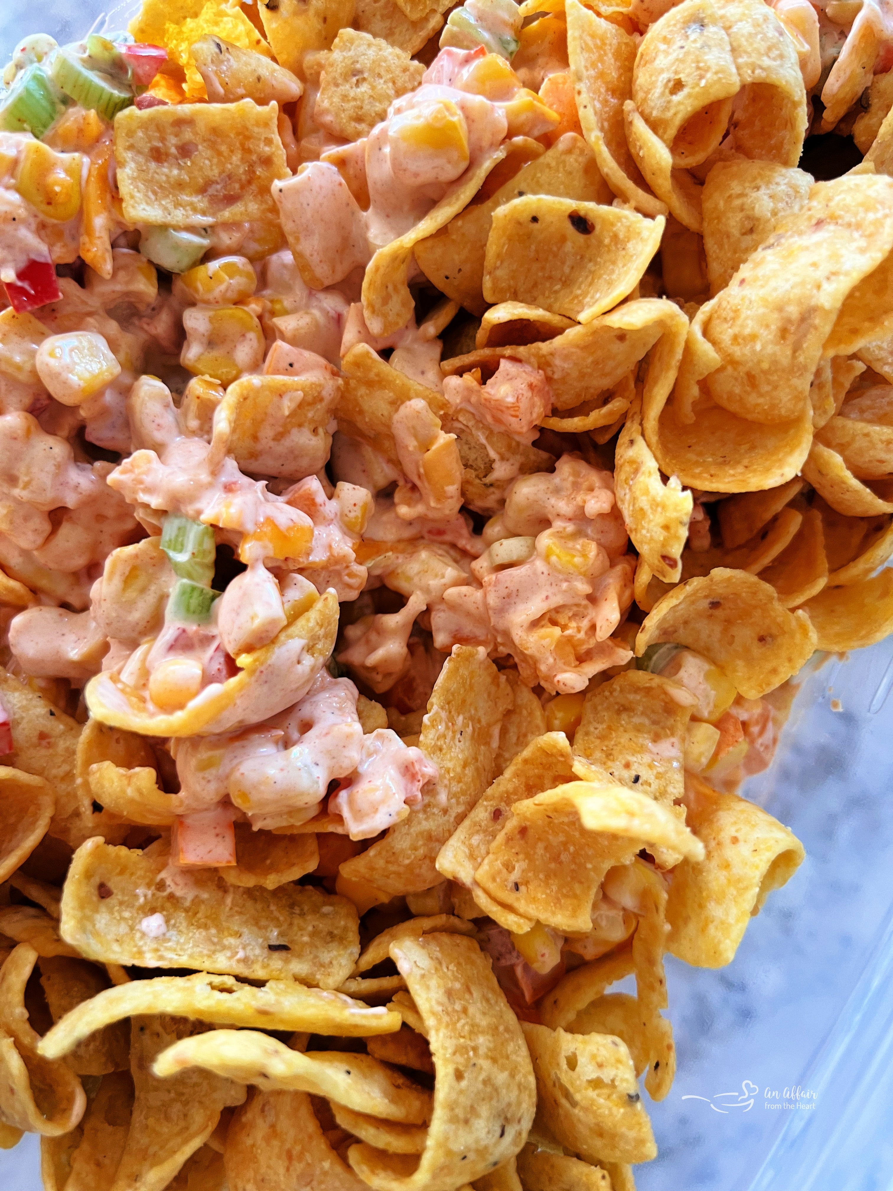 Fiesta Frito Corn Salad 8 Step 4: Stirring Frito corn chips into the chilled corn salad just before serving