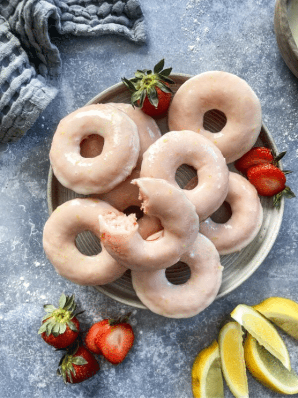 Baked strawberry lemonade donuts, stacked on a white plate