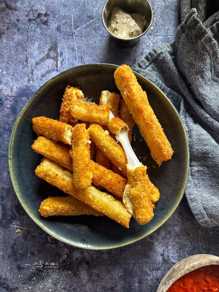 Mozzarella sticks on a green plate.