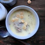 Oyster stew topped with oyster crackers in a white bowl