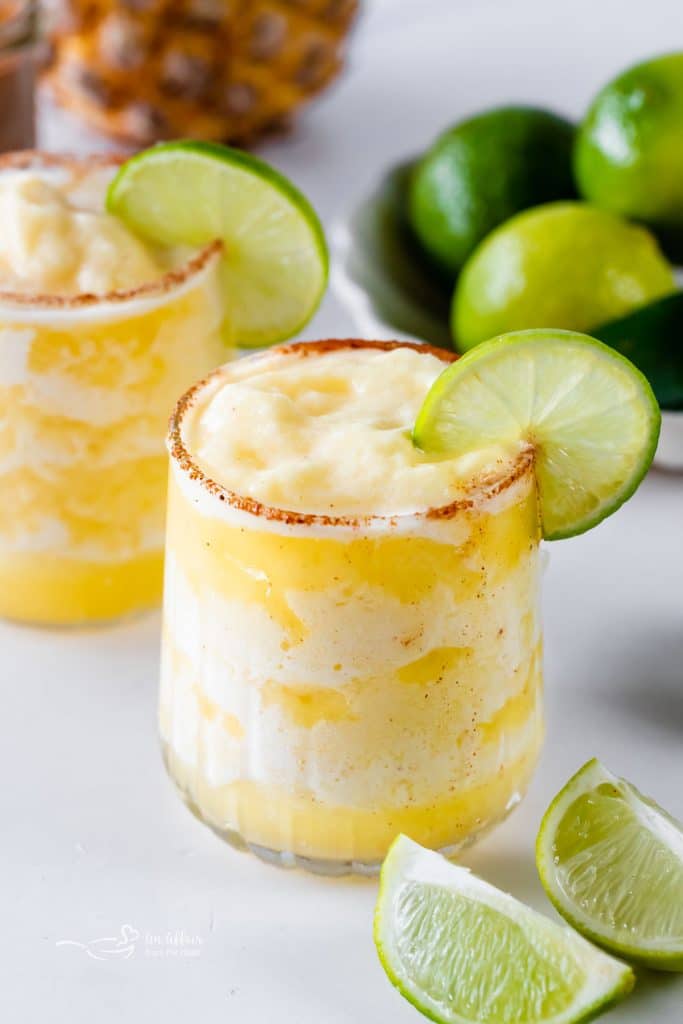 Close up of Frozen Pineapple Margarita garnished with a slice of lime.