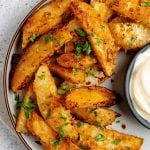 Roasted parmesan garlic potato wedges on a serving plate.
