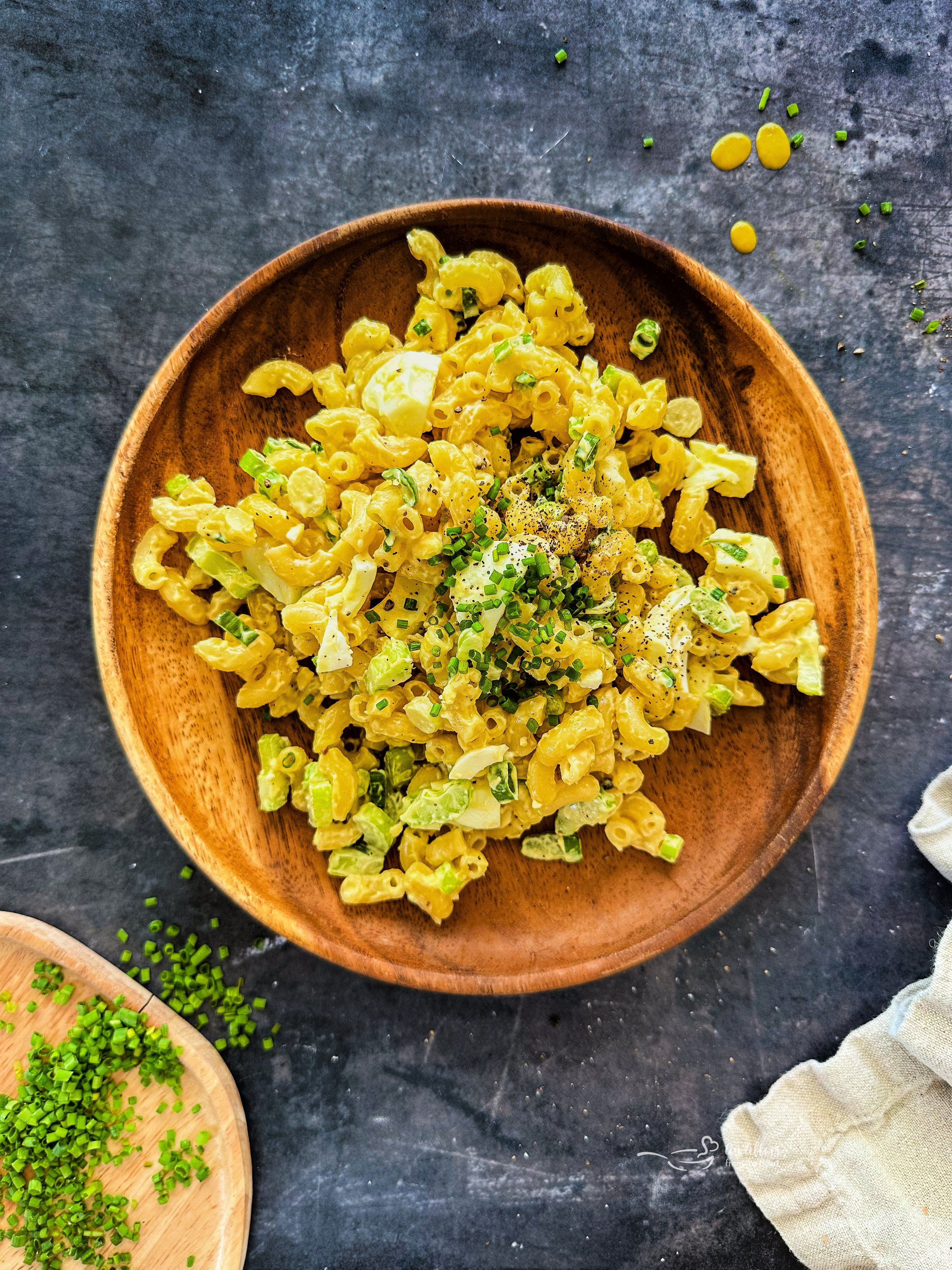 Mom's Macaroni salad on a wooden plate.