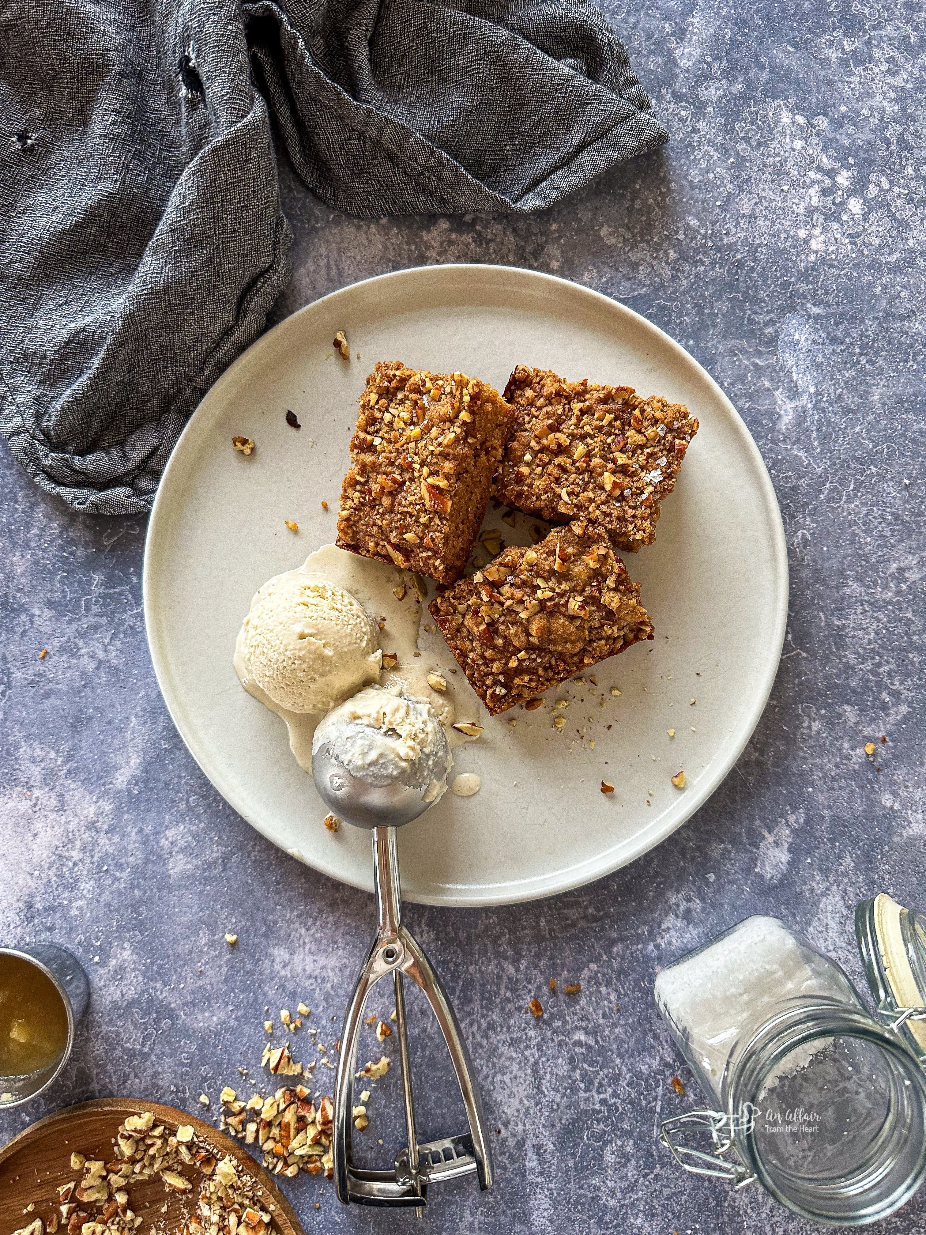 Three pieces of Applesauce coffee cake and ice cream on a white plate.