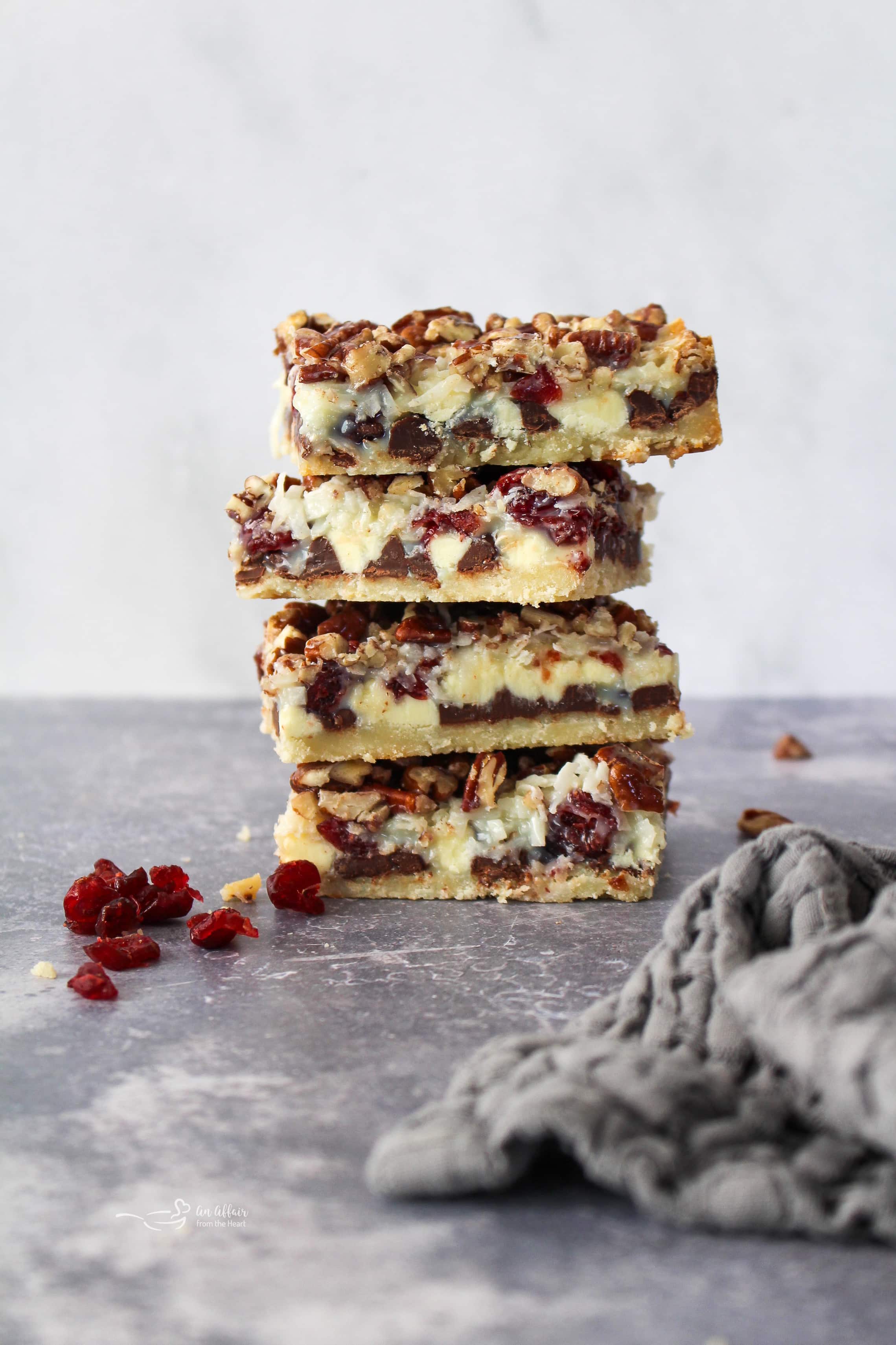 Double Chocolate Cranberry Magic Bars stacked on a gray surface