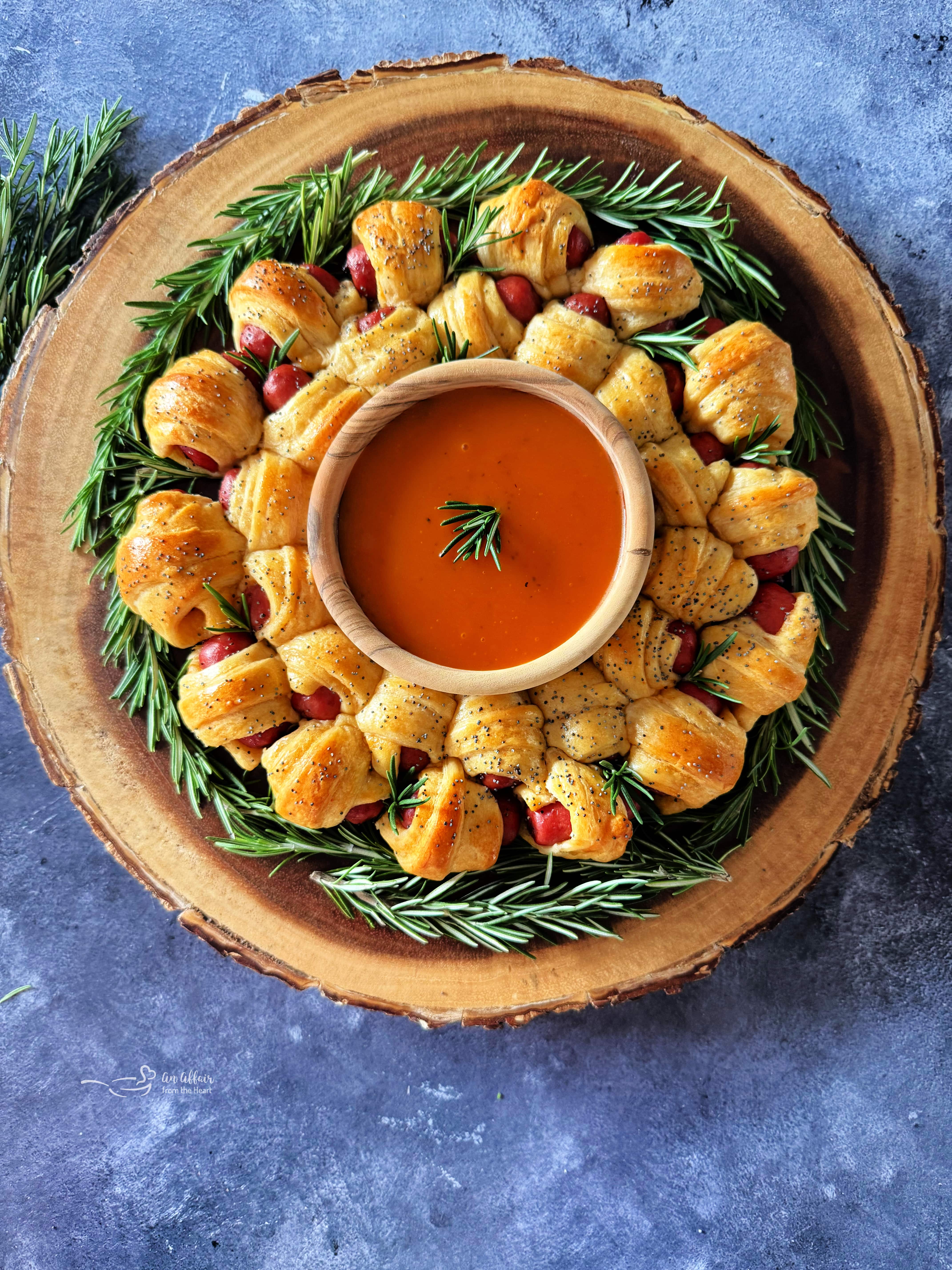 Overhead of Pig in a Blanket Wreath with a small bowl of Dorothy Lynch dressing in the middle