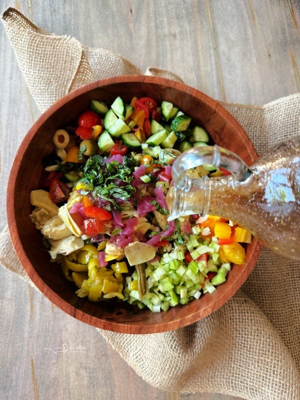 Mediterranean Dressing being poured over Pickled Vegetable Salad.