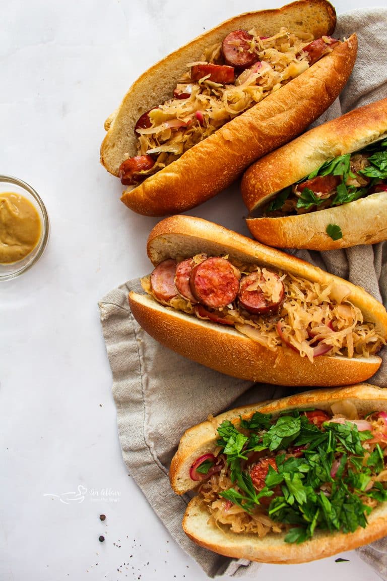 Closer view of four Sauerkraut and Kielbasa Hoagies on a tan tea towel.