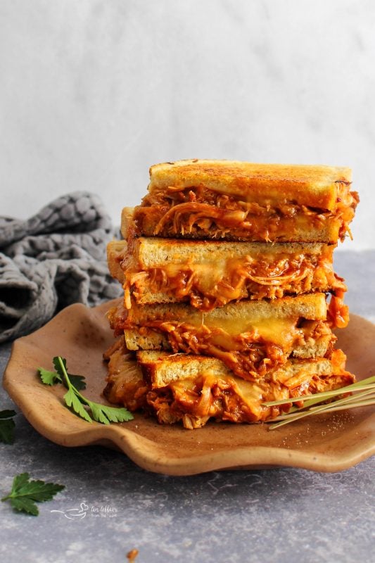 Pulled Pork Grilled Cheese halves stacked on a plate.